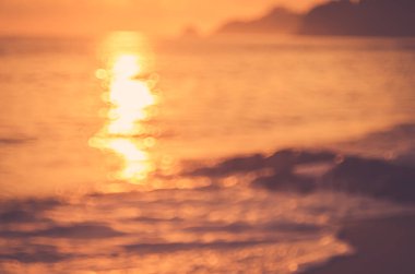 Tropikal günbatımı plaj ile bokeh güneş ışık dalga arka plan bulanıklık.