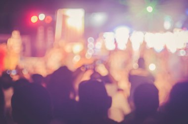 Gece açık konserinde renkli bokeh arka plan ile akıllı telefon alan insanlar bulanıklık.
