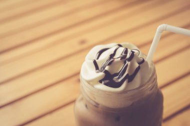 Ahşap masa arka plan üzerinde buzlu kahve. Alan sığ bölümü. 