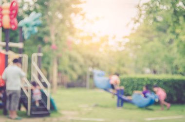Çocuklar oynarken oyun alanında park arka plan bulanıklık.