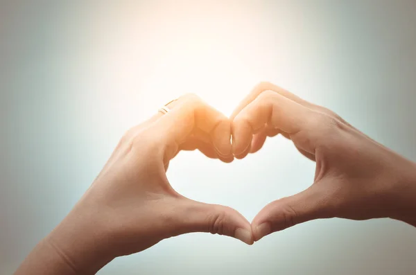 Mani femminili a forma di cuore sul cielo . — Foto Stock