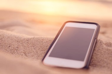 Kum plaj doku arka plan üzerinde Akıllı telefonunuzu kapatın. 