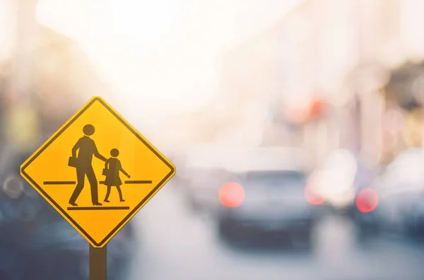 Okul bölge uyarı işareti ile renkli bokeh ışık arka plan bulanıklık trafik yolda. 