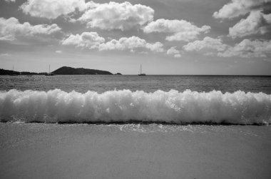 Tropikal plaj ve dalga beyaz bulutlar arka plan ile.