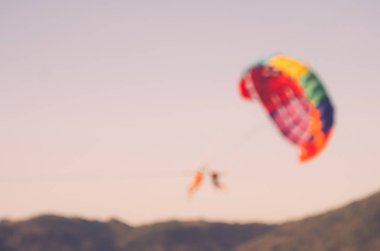 Bulanıklık insanlar rahatlamak tekne arka plan paraşütle atlama ile tropikal sunset Beach.