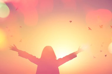 Özgürlük ve hissediyorum iyi kavramı. Kopya alanı yükselen siluet kadının günbatımı gökyüzü çift pozlama renkli bokeh ışık eller ve sinek arka plan kuş. Vintage sesi filtre efekti renk stili.