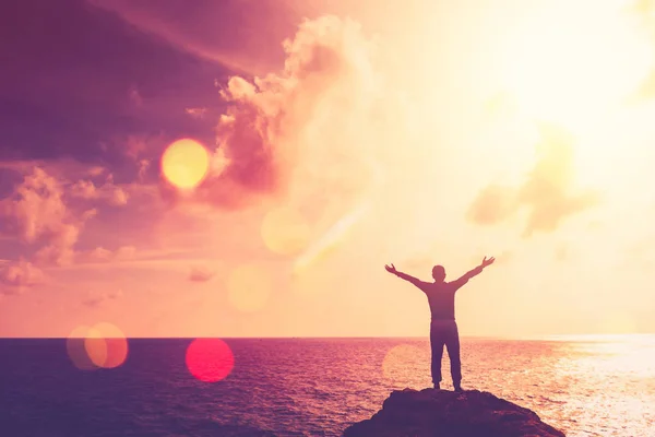 Copiar el espacio del hombre feliz mano levantar en la cima de la montaña en la playa tropical y puesta del sol cielo fondo abstracto . — Foto de Stock