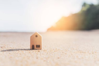 Gün batımı plaj kum doku arka plan küçük ev modeli.
