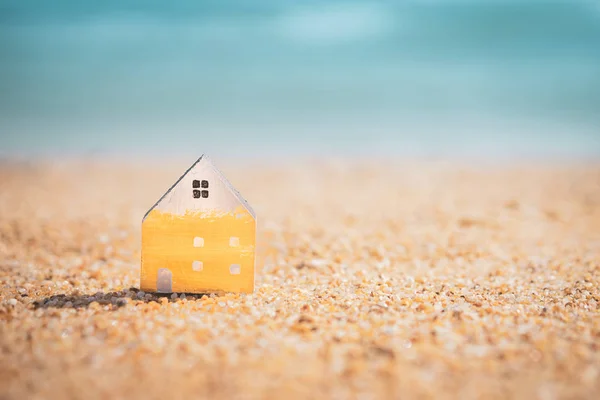 Modelo pequeno casa no pôr do sol praia areia textura fundo . — Fotografia de Stock