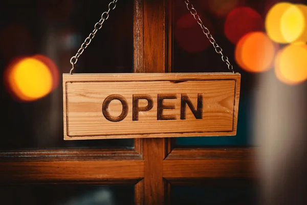 Teken breed opknoping op houten deur voorkant van café open. — Stockfoto