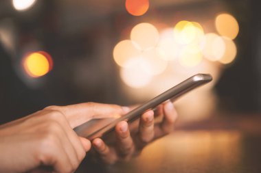 Kahve dükkanında akıllı telefon kullanan bir kadın. Teknoloji sektörü konsepti.