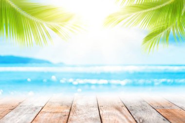 Tropik sahilde boş eski ahşap masa arka plan bokeh güneş ışık dalga ve palmiye ağacı ile bulanıklık.