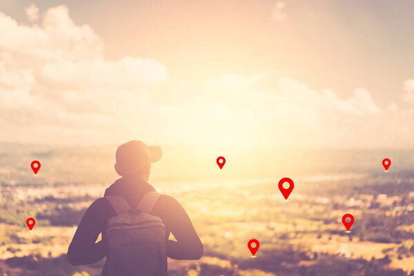 Backpacker man standing at top of mountain looking view landscape with navigator gps location abstract background. 