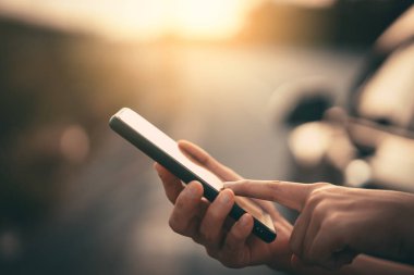 Kadın el yakından tutun park açık sokak arka plan üzerinde akıllı telefon kullanma.