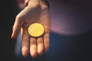 Kadın eli üzerinde Bitcoin. Teknoloji sektörü ve finansal konsept. 