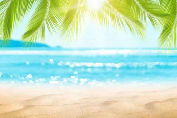 Sfocatura bella natura foglia di palma verde sulla spiaggia tropicale con bokeh sole onda di luce sfondo astratto . — Foto Stock