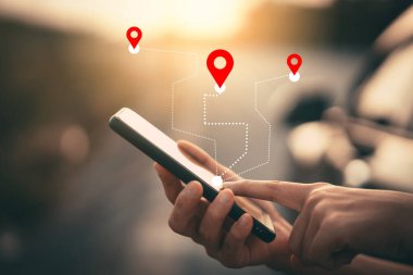 Bulanık sokak arka planında GPS haritası simgesi olan akıllı telefon kullanan bir adam eli.