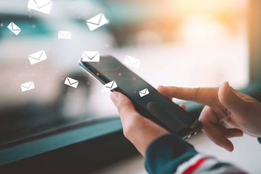 E- posta simgesi soyut olarak uçan bir kafede akıllı telefon kullanan bir kadın..