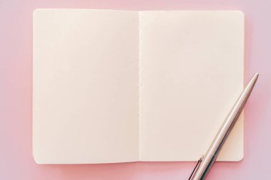 Pembe doku arka planında defter ve kalem.