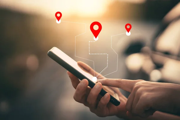 Bulanık sokak arka planında GPS haritası simgesi olan akıllı telefon kullanan bir adam eli.