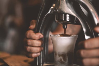 Adam kafede sıcak kahve yapıyor. Gıda ve iş konsepti. 