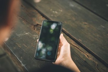 Kahve dükkanında akıllı telefon kullanan bir kadın. Teknoloji sektörü konsepti.