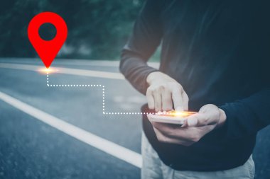 Bulanık sokak arka planında GPS haritası simgesi olan akıllı telefon kullanan bir adam eli.