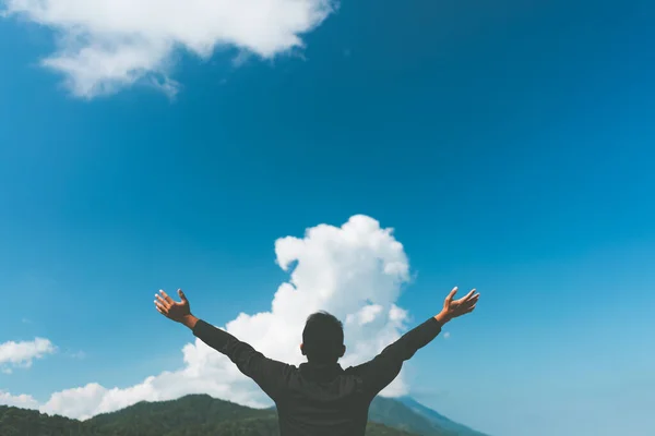 Espaço cópia do homem mão levantando no topo da montanha e céu azul nuvem branca fundo . — Fotografia de Stock