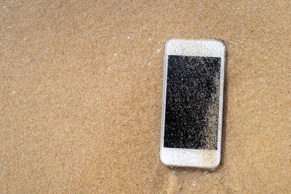 Chytrý telefon na pískové pláži textury pozadí. — Stock fotografie