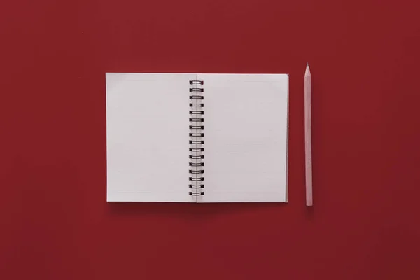 Notebook and pencil on red texture background. — Stok fotoğraf