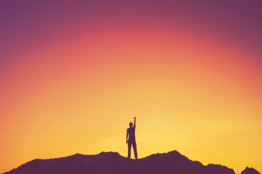 İnsan elinin dağın tepesine yükselişini ve günbatımı gökyüzünün soyut arkaplanını kopyala. Özgürlük yolculuğu macerası ve iş zaferi kavramı. Klasik ton filtre efekti renk biçimi.