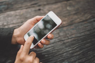 Kahve dükkanında akıllı telefon kullanan bir kadın. Teknoloji işi konsepti. Klasik ton filtre efekti renk biçimi.