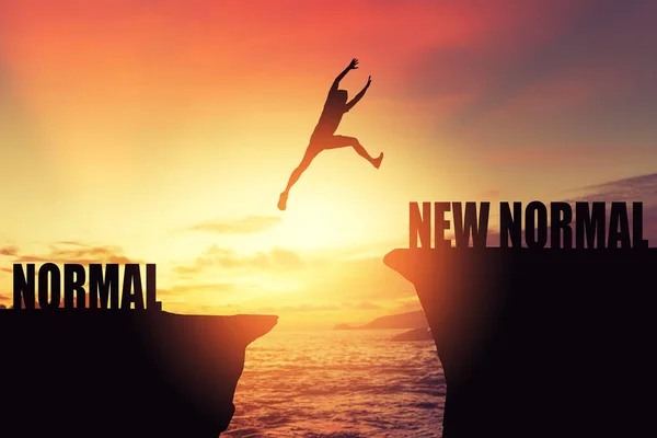 Siluet adam tropik günbatımı plajında uçurumun arasında yeni bir kelimeyle zıplıyor. Özgürlük mücadelesi ve seyahat macera tatili konsepti. Klasik ton filtre efekti renk biçimi.