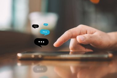 Kadın eli, kafenin soyut arka planında sohbet ikonu grafiği olan akıllı telefon kullanıyor. Teknoloji sektörü ve serbest meslek kavramı. Klasik ton filtre efekti renk biçimi.