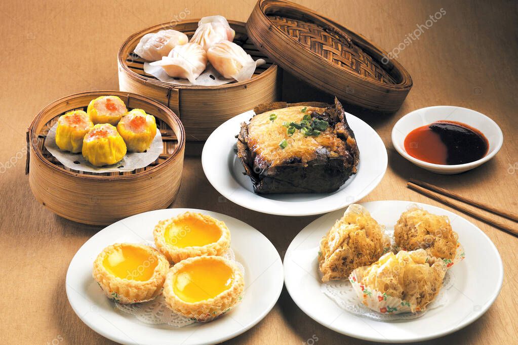 Assorted asian food dim sum in bamboo steamer and plate