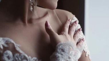 Beyaz elbiseli kız elini sıvazlıyor.