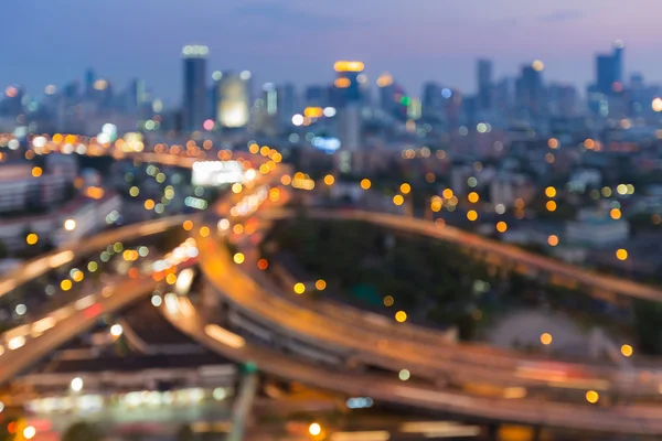 Fundo abstrato, luzes borradas bokeh rodovia trocada e cidade vista noturna do centro — Fotografia de Stock