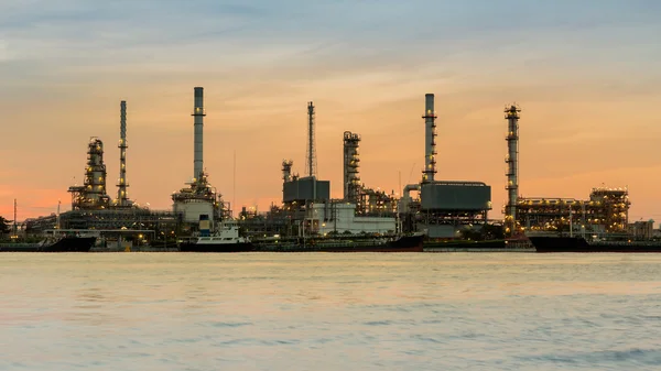 Refinería de petróleo frente al río durante el amanecer cielo — Foto de Stock