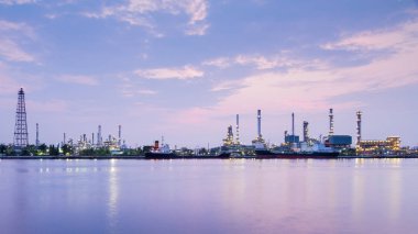 Panorama over oil refinery river front with sunrise sky  clipart