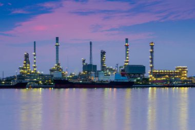 Petrol rafinerisi alacakaranlık gökyüzü ile ön Nehri