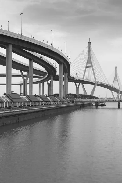 Bianco e nero, Ponte sospeso fronte fiume — Foto Stock