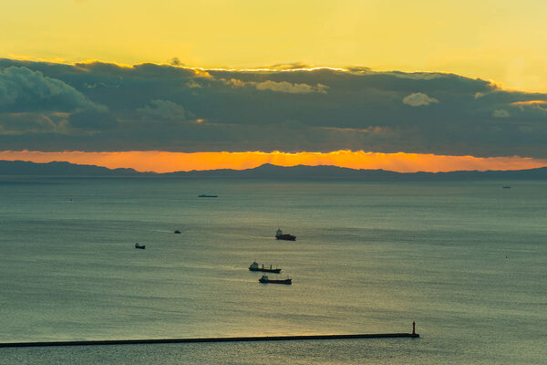 Sunset over coastline with transport ship