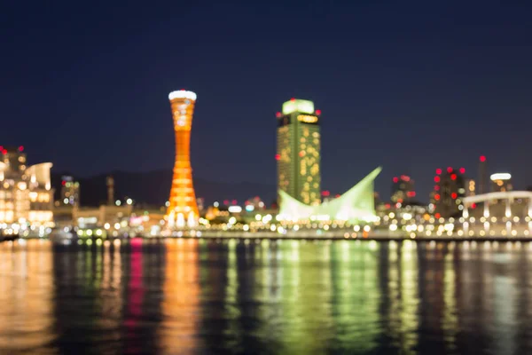 Noite borrada bokeh luzes Kobe torre portuária com reflexão de água — Fotografia de Stock