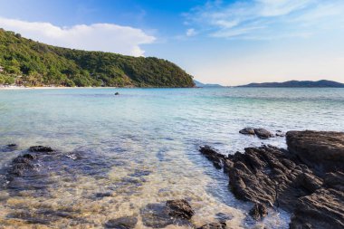 Doğal kayalık plaj sahil ve mavi gökyüzü arka plan üzerinde