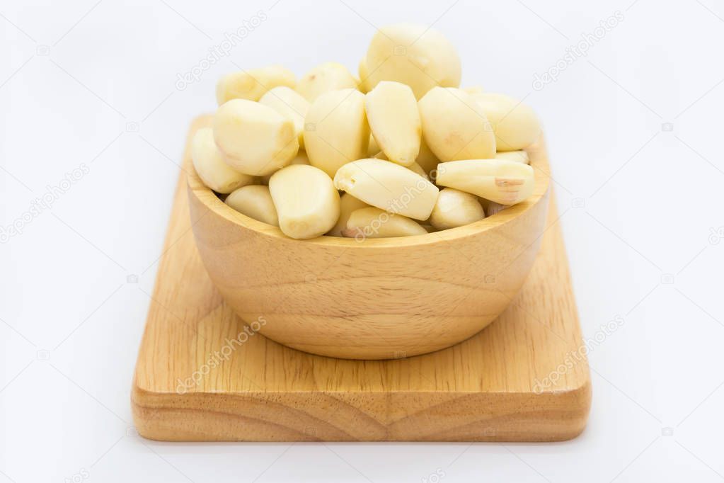 Fresh raw garlic on wooden bowl