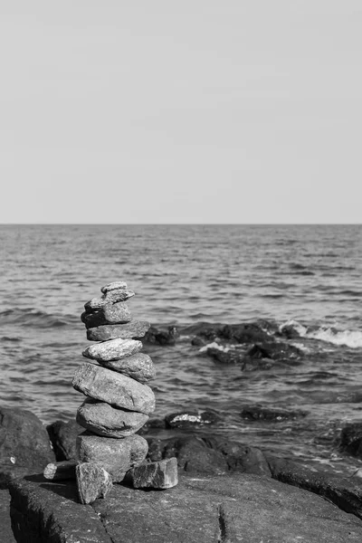 Fekete-fehér sziklák verem a part háttérben — Stock Fotó