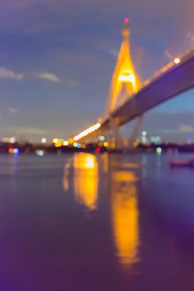 Pont suspendu à lumière floue traversant la rivière et reflet vue de nuit — Photo