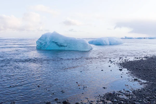 아이스 큐브 깨는 검은 작은 바위 해변에 전면 빙하 — 스톡 사진