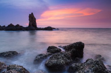 Sahil günbatımı gökyüzü arka plan ile doğal taşın