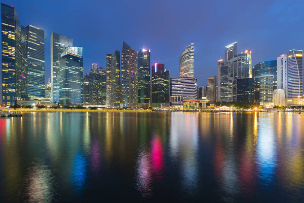 Twilight blue sky background, Singapore office building and reflection light night view